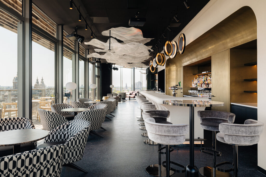 LuminAir sky bar interior in Amsterdam, with patterned seating, panoramic windows and cloud-inspired ceiling lights