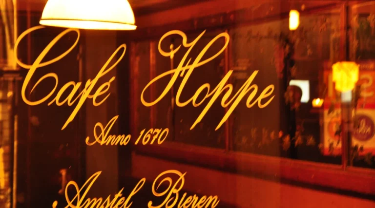 Warmly illuminated Caf&eacute; Hoppe lettering on the window of the historic brown caf&eacute; on Spui in Amsterdam