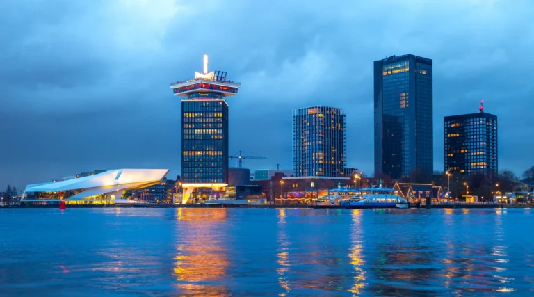 Amsterdam Noord waterfront with EYE Filmmuseum and A&rsquo;DAM Tower reflected in the IJ at dusk