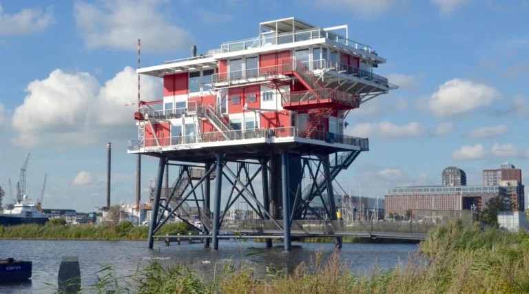 Red and white REM restaurant platform standing above the water in Amsterdam Houthaven