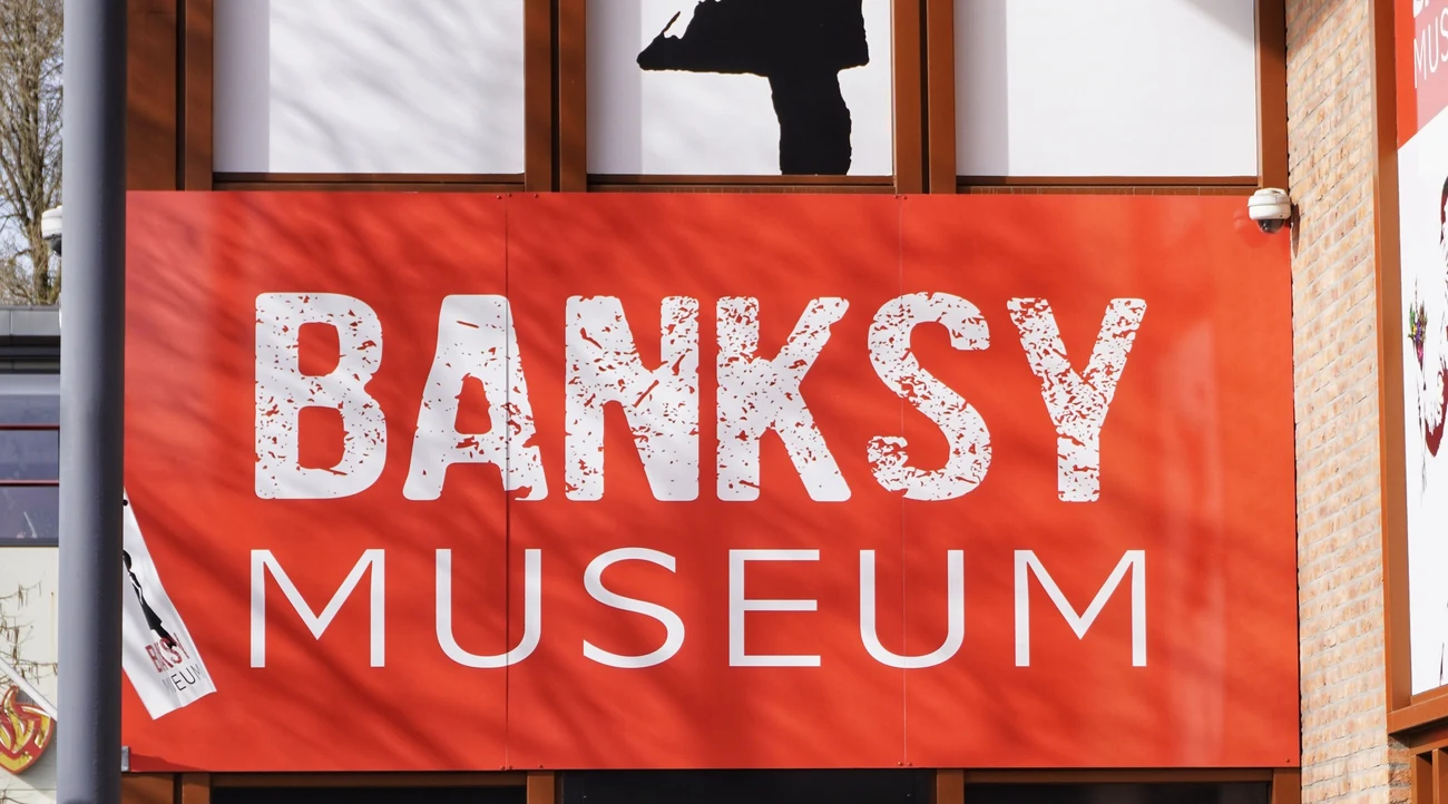 Red Banksy Museum sign above the entrance at Van Slingelandtplein in Amsterdam, photographed in daylight