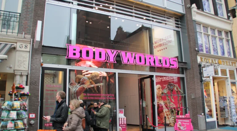 BODY WORLDS entrance on Damrak in Amsterdam with its pink sign and anatomical exhibition posters