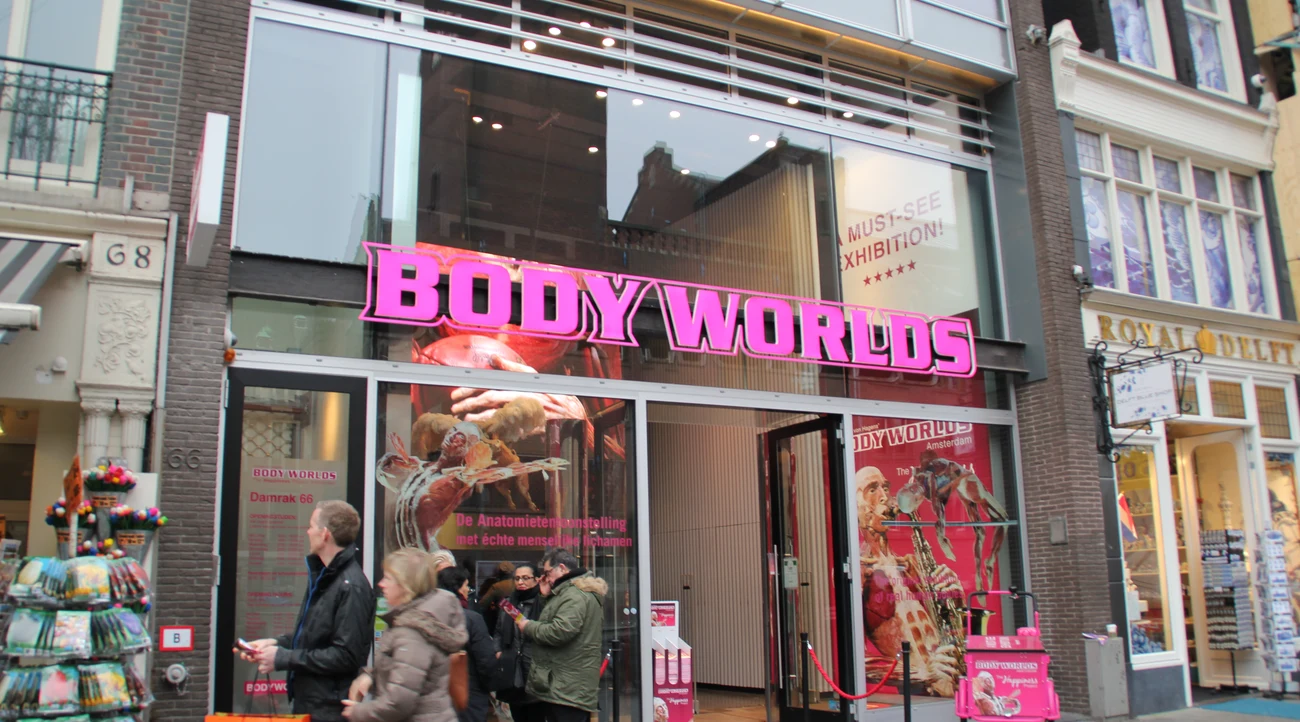 BODY WORLDS entrance on Damrak in Amsterdam with its pink sign and anatomical exhibition posters