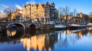 Gabled houses, arched bridge and moored boats at Brouwersgracht and Prinsengracht in Amsterdam in daylight