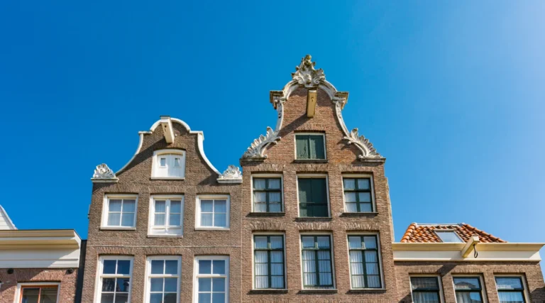 Decorative gables of historic houses on Haarlemmerstraat in Amsterdam under a clear blue sky