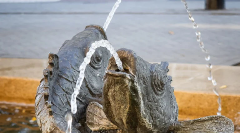 Close view of the bronze fish sculptures and water jets of the Hans Snoek Fountain at Leidseplein in Amsterdam in daylight