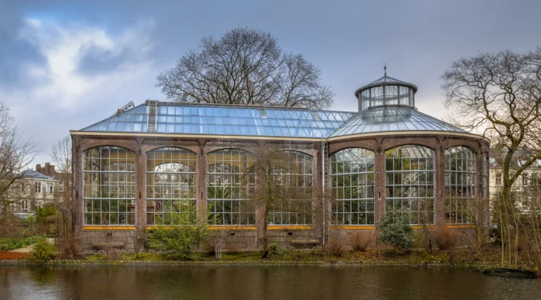 The historic Palm House beside the water at Hortus Botanicus Amsterdam