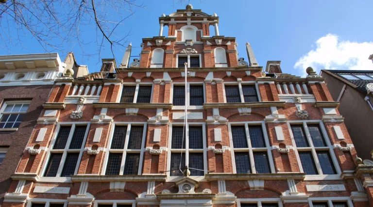Daylight view of the brick fa&ccedil;ade and sculpted heads of Huis met de Hoofden in Amsterdam