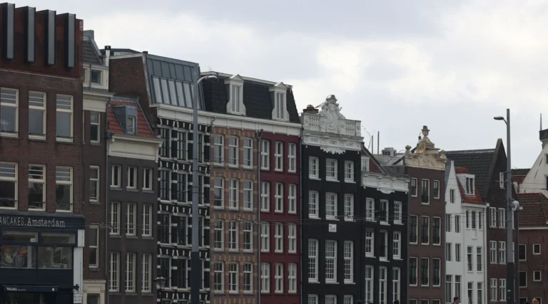 Quaint canal-side buildings in Amsterdam showcasing iconic Dutch architecture.