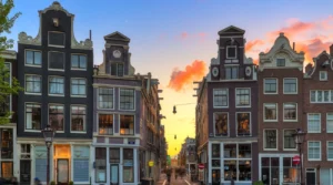 Historic gabled houses framing a street in Amsterdam&rsquo;s Nine Streets area at sunset