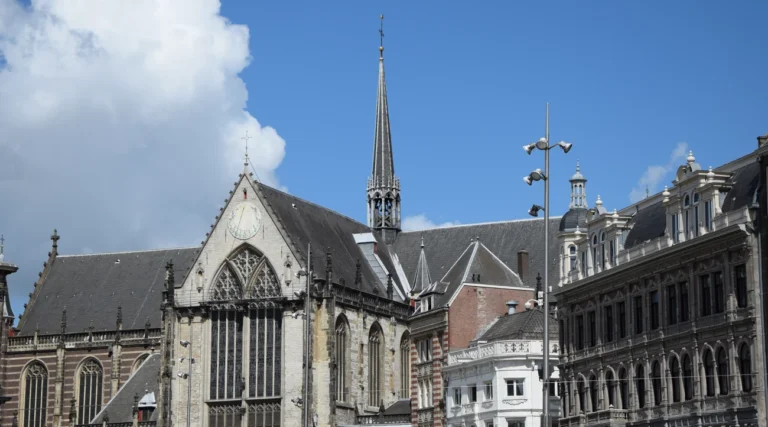 Gothic facade and slender spire of Nieuwe Kerk on Dam Square in Amsterdam in daylight