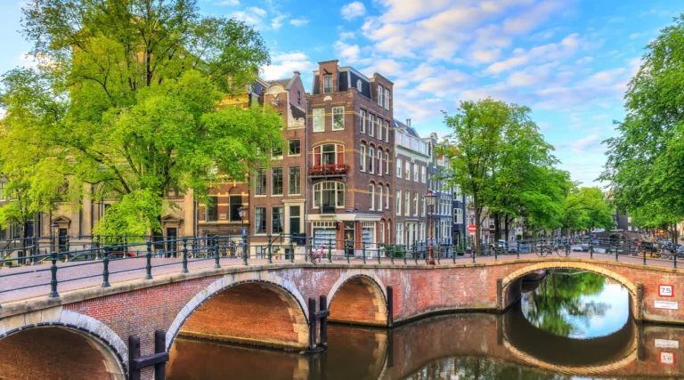 Brick arched bridges and canal houses at the Prinsengracht and Reguliersgracht junction in Amsterdam on a sunny morning