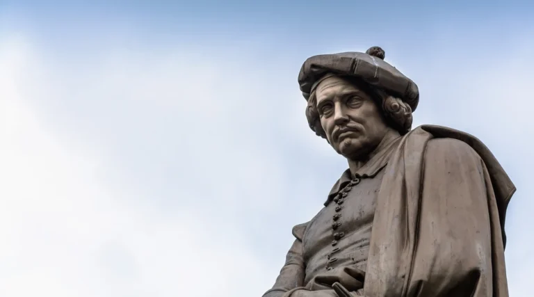Rembrandt van Rijn statue on Rembrandtplein in Amsterdam against a pale daytime sky