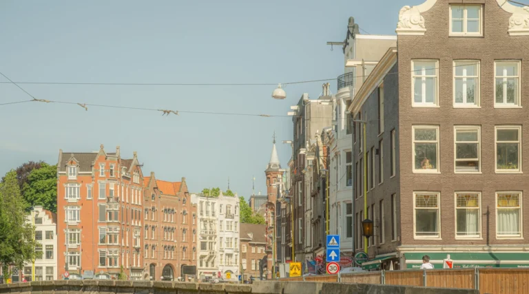 Historic facades and a bridge beside the Rokin waterway in central Amsterdam in daylight