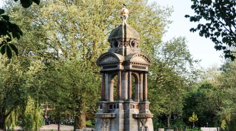 Samuel Sarphati monument and fountain with its crowned roof among green trees in Sarphatipark, Amsterdam, in daylight