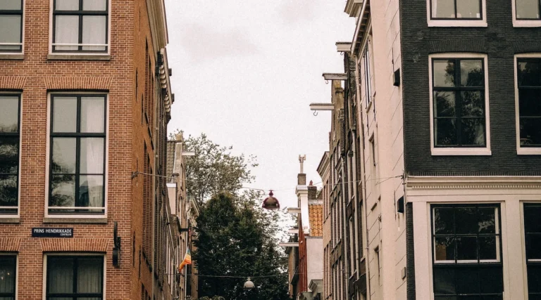 Charming Amsterdam street featuring classic Dutch architecture with bikes and a motorcycle.