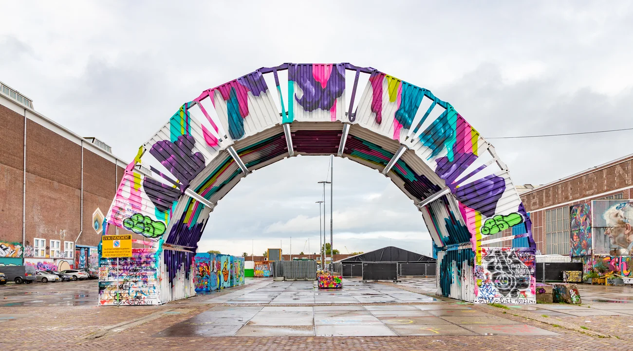 Colourful arch installation beside STRAAT Museum at the NDSM shipyard in Amsterdam during daylight