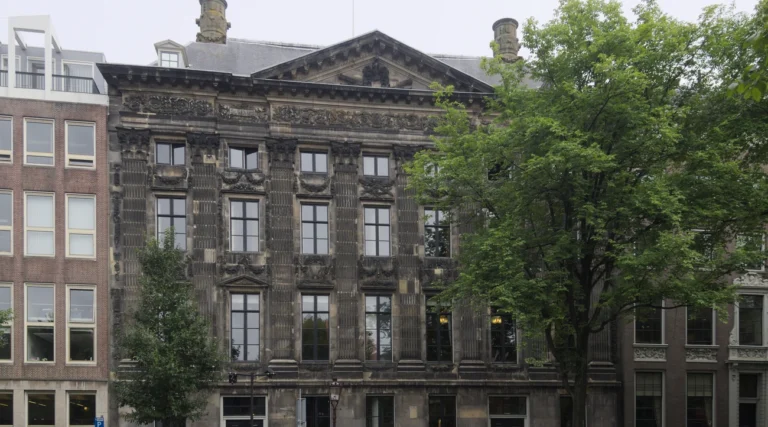Classical stone fa&ccedil;ade and pediment of Trippenhuis on Kloveniersburgwal in Amsterdam