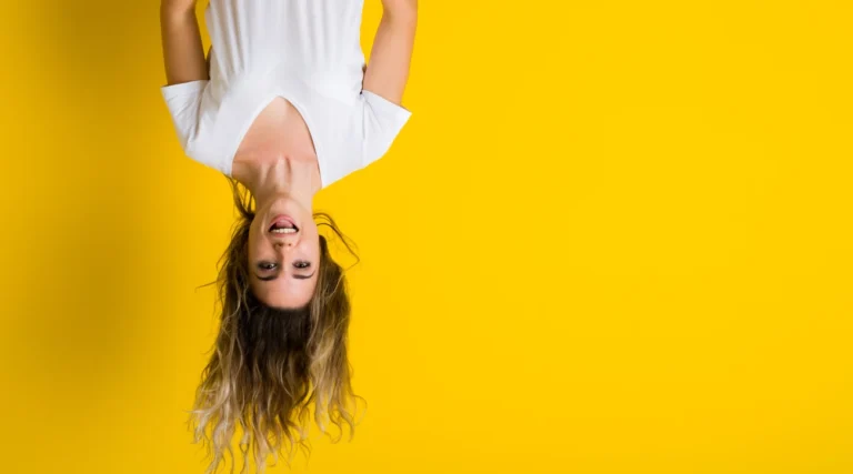Illustrative upside-down portrait of a woman against a bright yellow background