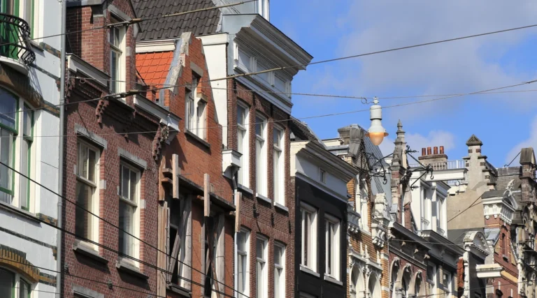 Historic facades and suspended street light above Utrechtsestraat in Amsterdam in daylight
