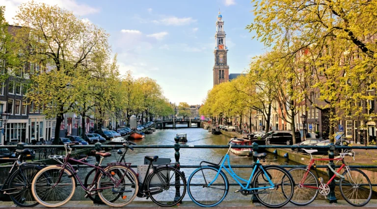 Bicycles on a bridge and the Westertoren rising above Prinsengracht in Amsterdam in late daylight
