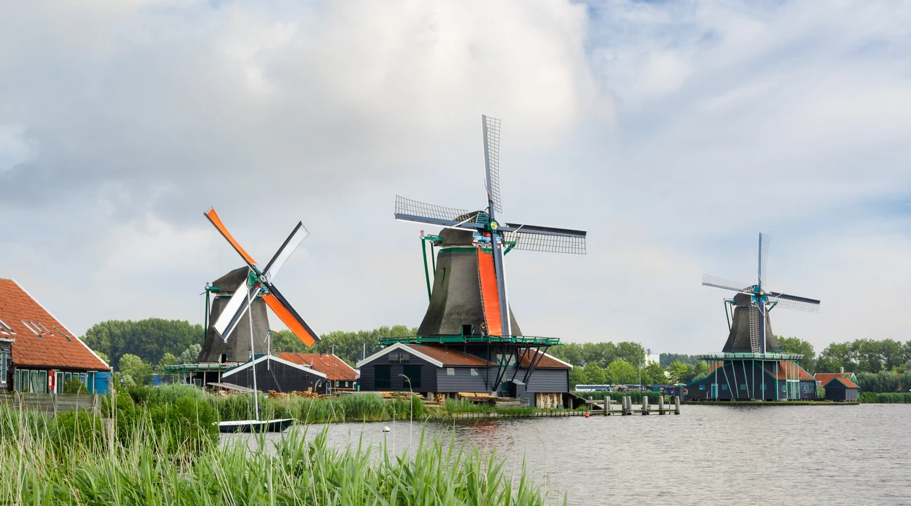 Traditional green windmills beside the Zaan river at Zaanse Schans in daylight