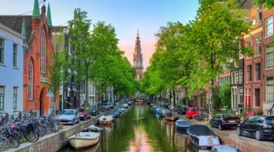 Zuiderkerk tower rising at the end of Groenburgwal canal in Amsterdam at sunset