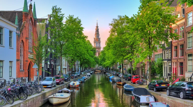 Zuiderkerk tower rising at the end of Groenburgwal canal in Amsterdam at sunset